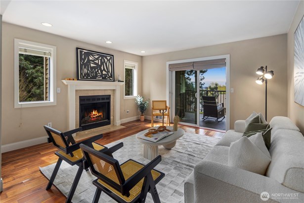 Light-filled end unit with westerly views of the city, Olympics, and Lake Washington. The living room features a cozy wood-burning fireplace and a slider to the covered deck with additional storage.