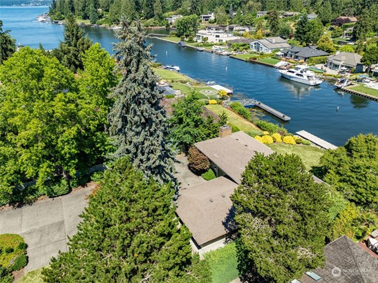 Welcome Home! This stunning aerial view showcases the property&#39;s prime waterfront location, lush landscaping, and private dock.