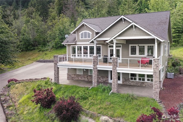 Drone shot of front of home. You will love the expansive deck overlooking Summit Lake, the large covered patio below and all the parking for you and your guests!