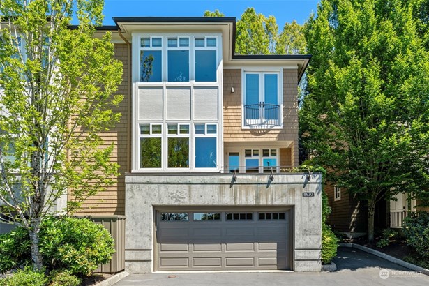 This classic, contemporary townhome features expansive windows, bathing the interior with natural light. Nestled in a lush, green setting, it features a spacious three-car garage and a stylish exterior just painted in 2022.