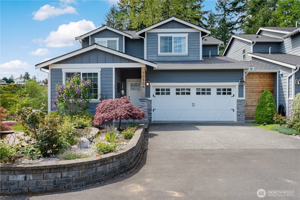 The inviting front of the house with the raised bed and rose garden.
