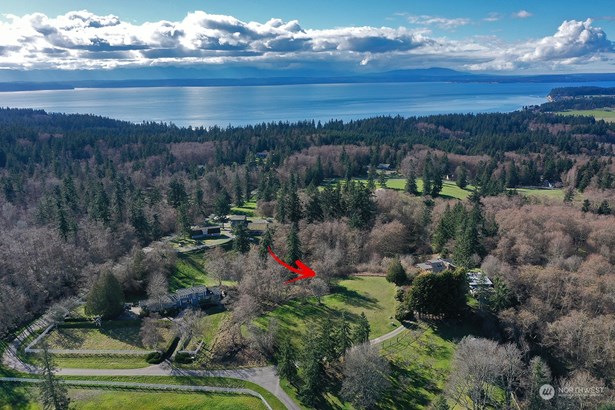 Enjoy the serene drive from Lancaster Road to your property. Quiet neighborhood with all homes on acreage. Photographer is facing west capturing Mutiny Bay & Admiralty Inlet.  **Please drive slowly and park with care.**
