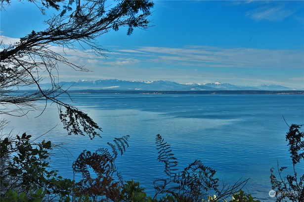 Breathtaking panoramic views extending from the majestic Olympic Mountains to the Strait of Juan de Fuca, Admiralty Inlet, and Admiralty Bay, with glimpses of Vancouver Island.