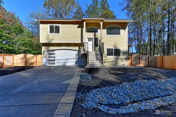 Exterior of Home with stamped concrete and dual gates in fencing.