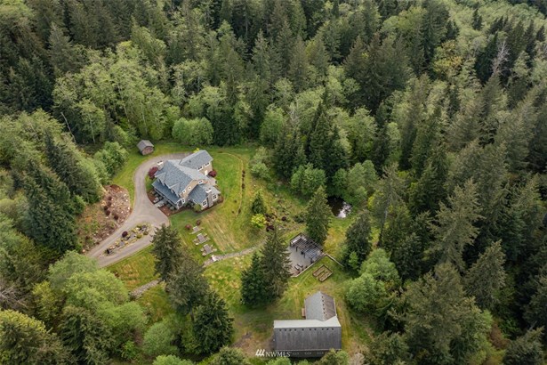 Nestled on 6.9 acres of privacy and tranquility, this expansive property includes its 3,970 sf home, a 2,800 sf shop building with additional office or living quarters, a large outdoor kitchen and entertaining area, a gardening area with raised beds, a small duck pond, and roughly 5 forested acres of elk trails to explore.
