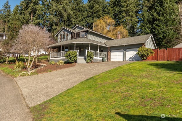 Edgewood. WA Traditional two story home with wrap around front porch. Plenty off street parking, also neighborhood has a overflow parking area. Home sits on a corner lot. White dogwood tree in front of home almost ready to bloom.