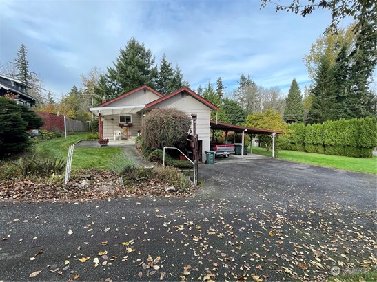 Perched on a large corner lot directly across from Whatcom Falls Park! 2 car carport and 1 car garage, covered patio and garden space.