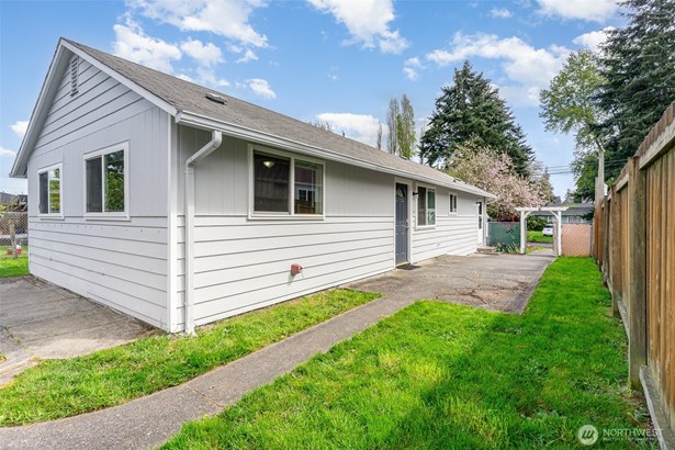 A welcoming side yard with low maintenance green grass leads you right to the entrance of the home, creating a peaceful first impression.