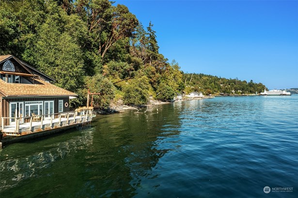 This charming home sits right down on the water with 170 feet of shoreline. Solar panels on the roof capture the all-day sunshine.