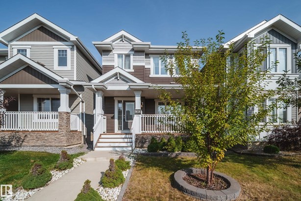 Craftsman-style home with covered porch and a front yard