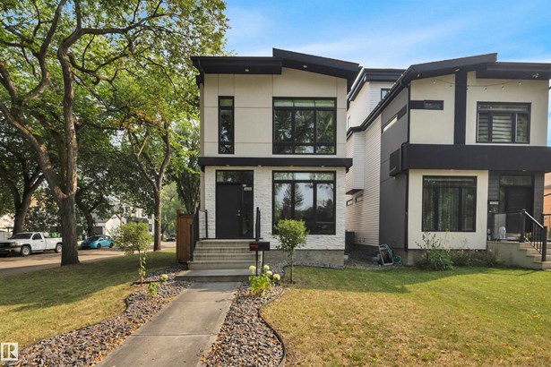 Contemporary house with stucco siding and a front lawn