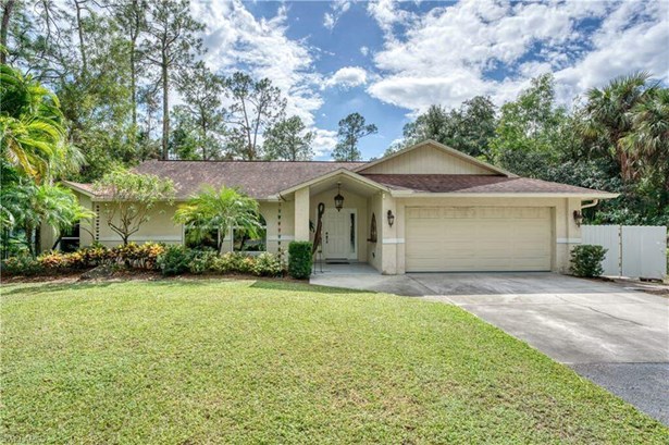 Ranch-style home featuring a front lawn and a garage