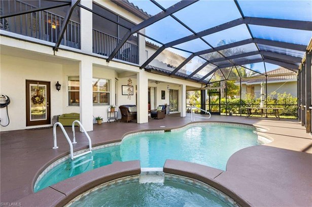 View of swimming pool featuring a patio area, an in ground hot tub, and glass enclosure