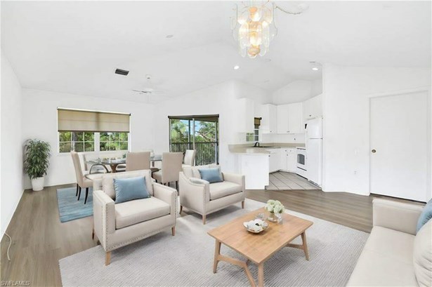 Virtually Staged - Great room with laminate floors, wonderful natural light and kitchen (to the right).